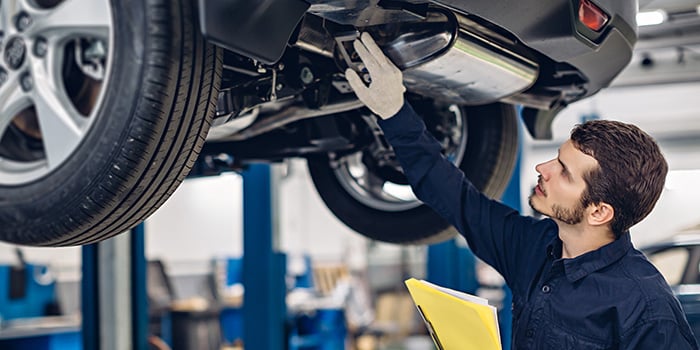 Service technician inspecting a vehicle